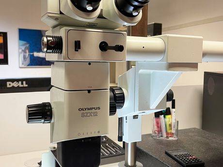 Olympus Stereomikroskop mit Doppelokular an einem Prüfplatz im Messraum.